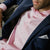 Model wearing big pink and white stripe extreme cutaway collar shirt with no tie and a navy suit