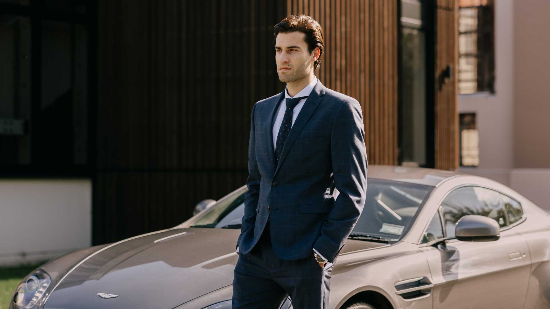 Model wearing navy suit with an extreme cutaway collar dress shirt